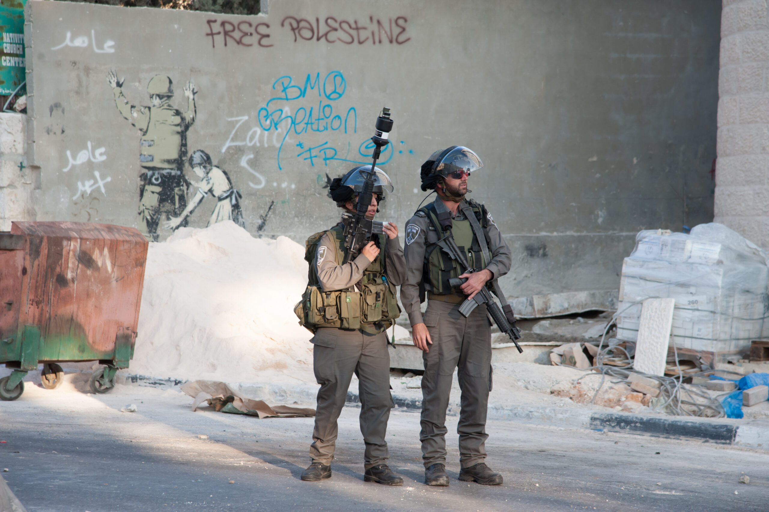 Betlemme, 20 novembre 2012 - Soldati Israeliani a Betlemme occupata, vicino al muro, con il murales di Banksy – Foto di Ryan Rodrick Beiler - Shutterstock