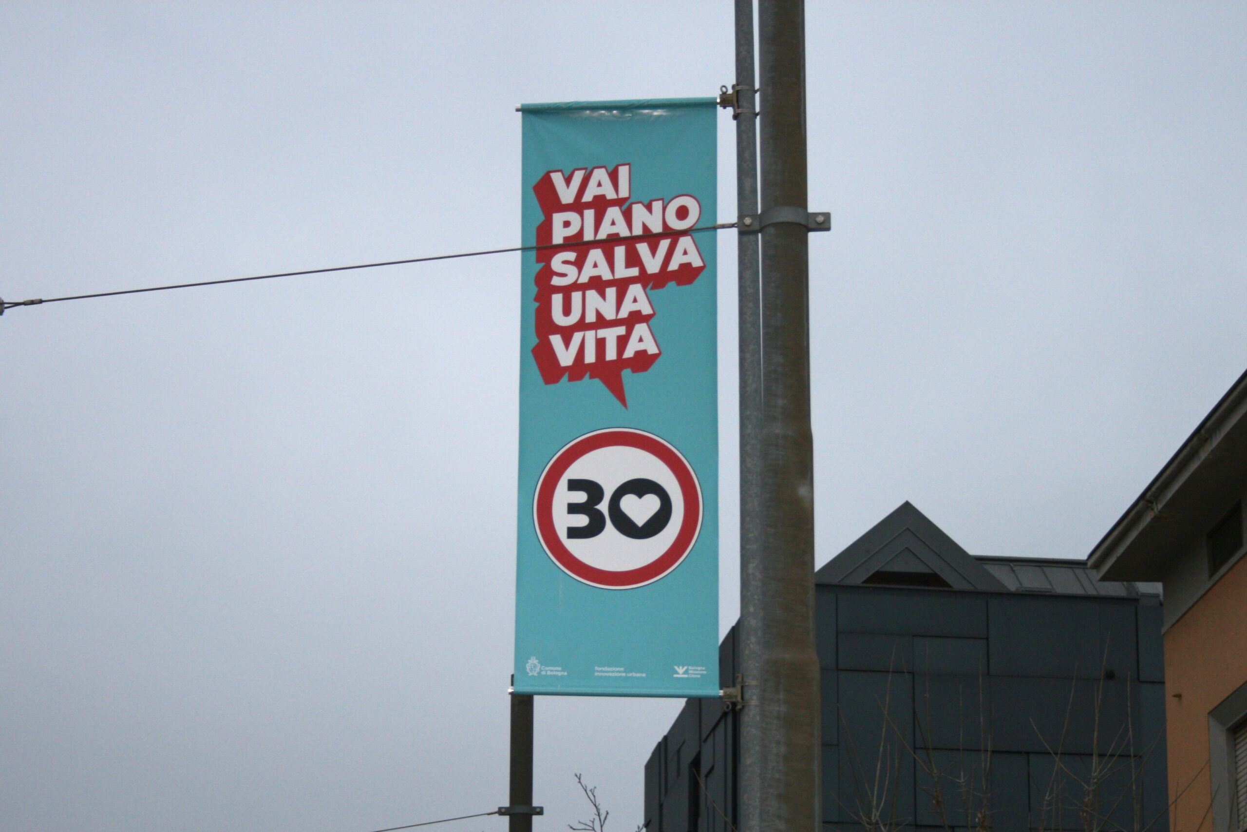 Cartello di Bologna Città 30 con scritto "VAI PIANO SALVA UNA VITA"